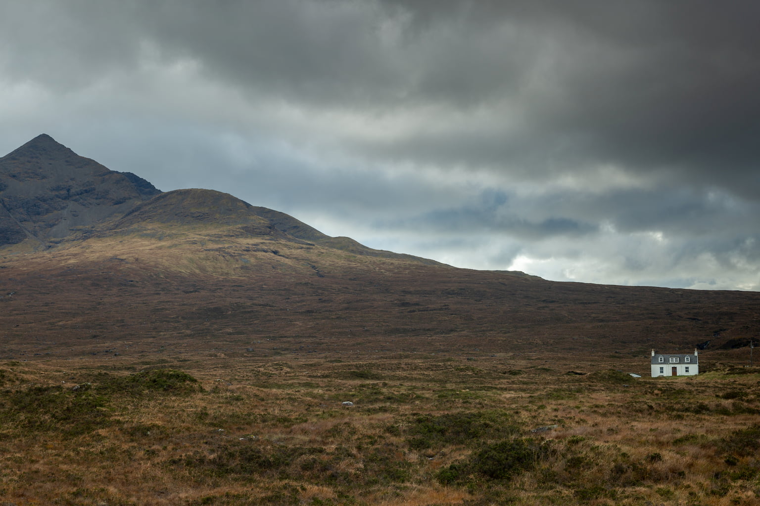 Grey skies over Allt Dearg Cottage on the Isle of Skye with Sgurr a Bhasteir on left hand side of photograph.