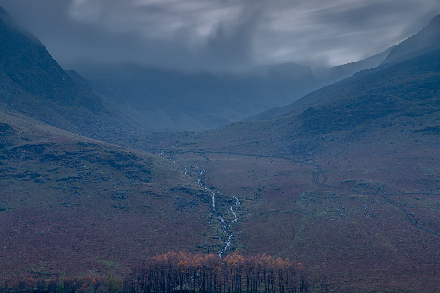 A very dark and wet day over Burtness comb in Buttermere, Lake Districk. Landscape photograph taken from across Buttermere lake. 