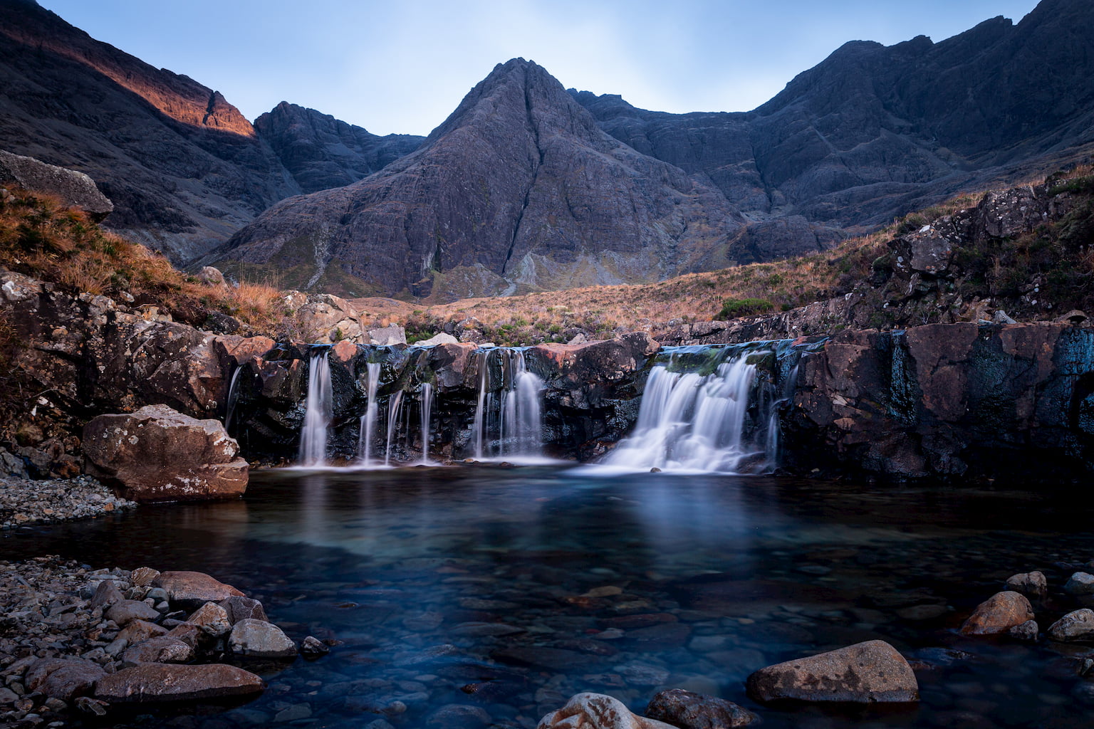The Fairy Pool Waterfalls on the Isle of Skye surrounded by the Black Cuillin Mountains.