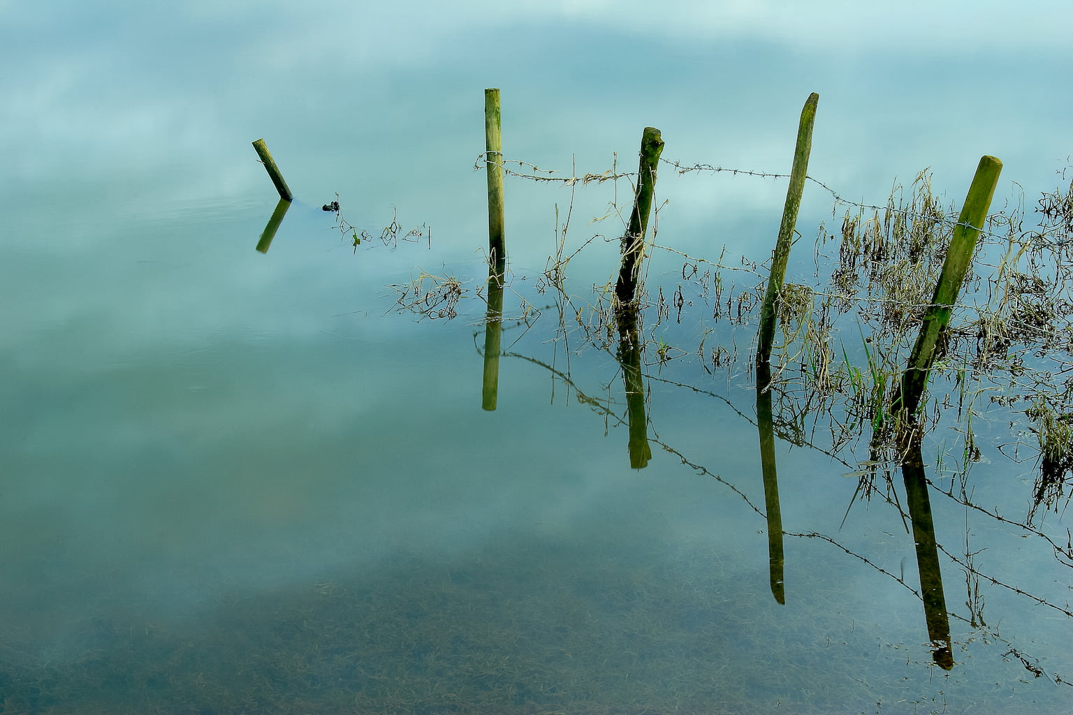 Refelctions of fence in the water at The Ouse Washes, near Sutton Gault in Cambridgesire.