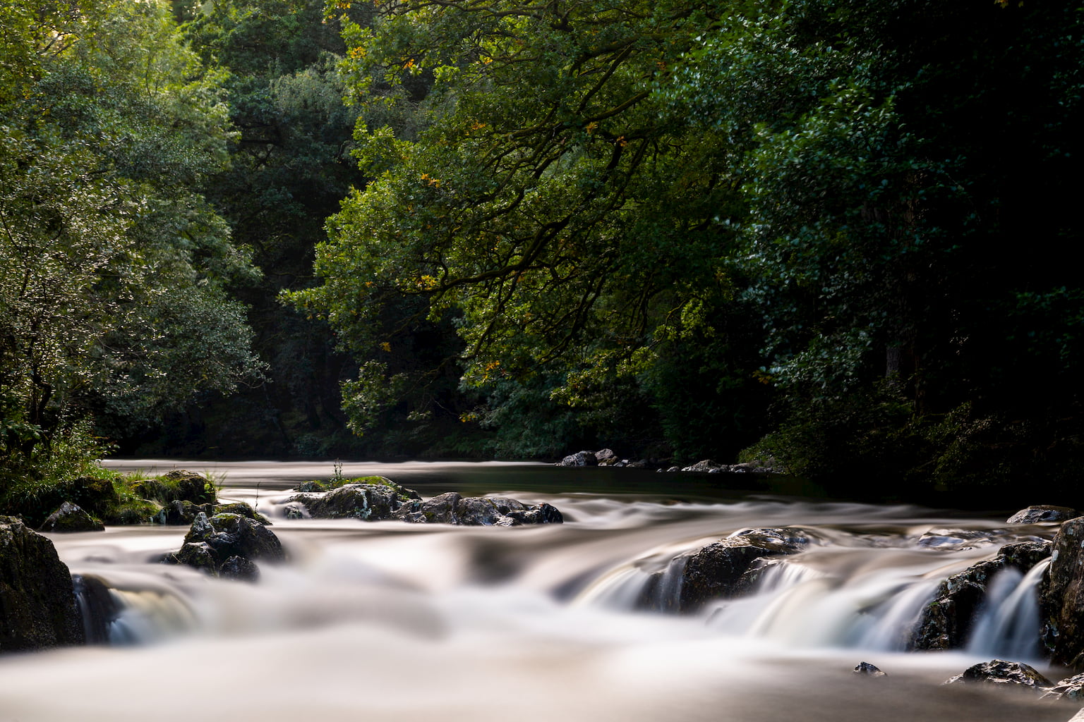 A long exposure photograph of the River Conwy in Betws-y-Coed in North Wales.