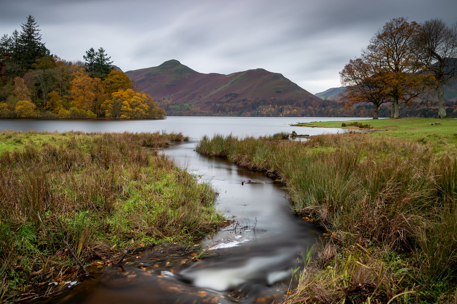 A long exposure landscape photograph of Strandshag Bay on teh shoreline of Derwentwater in the Lake District